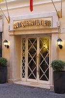A boutique hotel entrance with a sign reading "BOUTIQUE HOTEL TREVI".