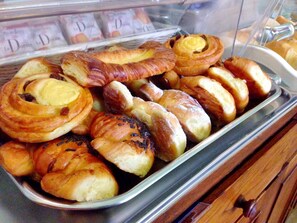 A display case filled with various baked goods, including croissants and rolls. - Hotel Desirée (Florence)