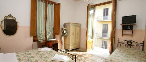 A bedroom with two beds, a dresser, a mirror, and a chandelier.
