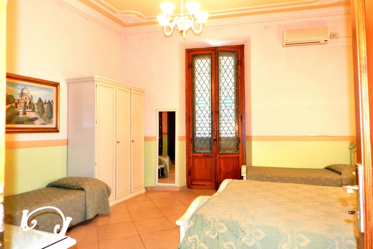 Une pièce comprenant un lit, une armoire, une chaise et une porte dotée d’un panneau en verre.