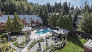 A residential area with a swimming pool, patio furniture, and a well-maintained lawn.