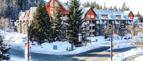 A snow-covered road with buildings in the background.