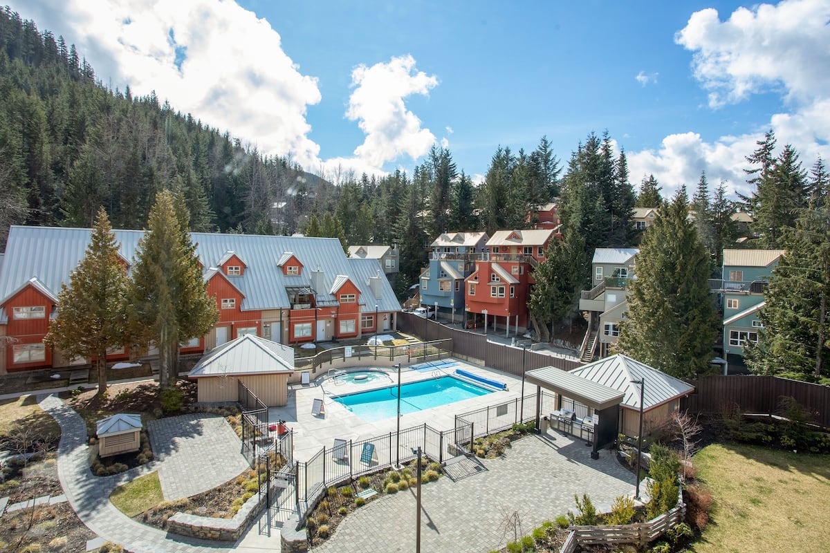 Un complexe hôtelier doté d’une piscine, de plusieurs bâtiments et situé dans un cadre montagneux.
