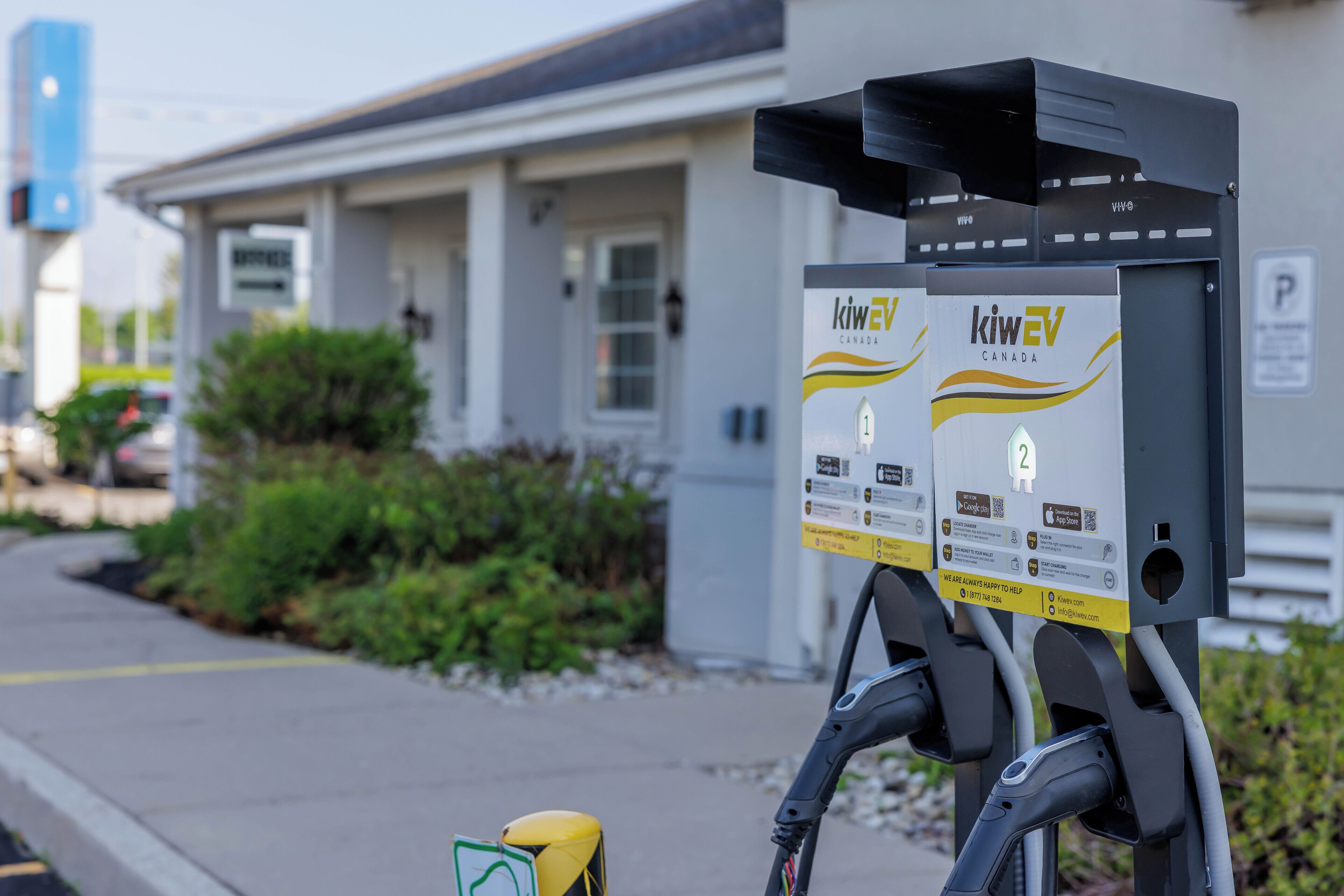 A charging station with two boxes labeled "kiweV Canada" for electric vehicles.