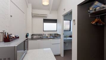 A compact kitchen with a sink, countertop, and a window above the sink.