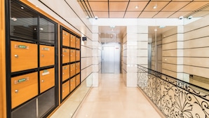 A hotel corridor with lockers on the left, a metal railing on the right, and a door at the end. - Cannes Croisette Prestige (Cannes)