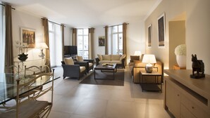 A spacious living room with a glass dining table, sofas, and a TV. - Cannes Croisette Prestige (Cannes)