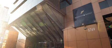 A modern building with a glass entrance and a sign for Boulevard Suites at 5749.