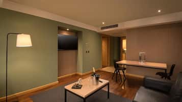 Una sala de estar moderna con un sofá, una mesa de centro con una botella de champán, y un comedor con mesa y sillas.