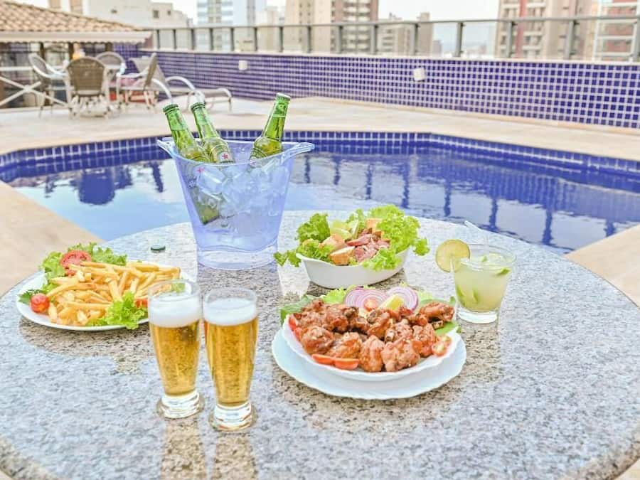 Una piscina al aire libre, sombrillas, sillones reclinables de piscina