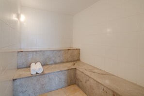 A corner of a bathroom with a marble sink and a pair of rolled towels on the counter. - Jk Premium Hotel e Eventos (Londrina)