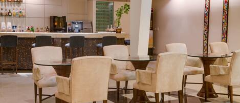 A modern hotel lobby with a bar area, seating arrangement, and decorative elements.