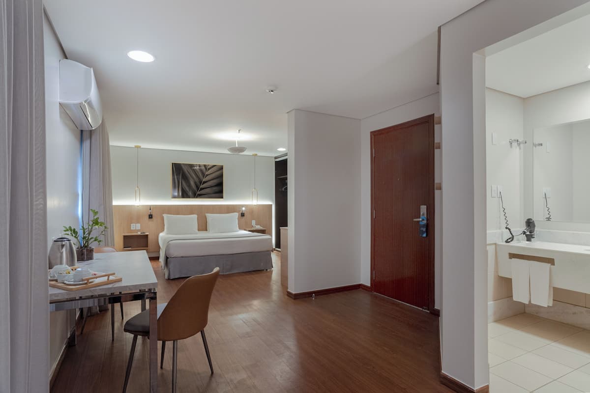 Una habitación de hotel moderna con una cama, una mesita de noche y un escritorio con una silla.