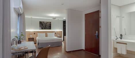 Une chambre d’hôtel moderne équipée d’un lit, d’une table de chevet et d’un bureau avec une chaise.