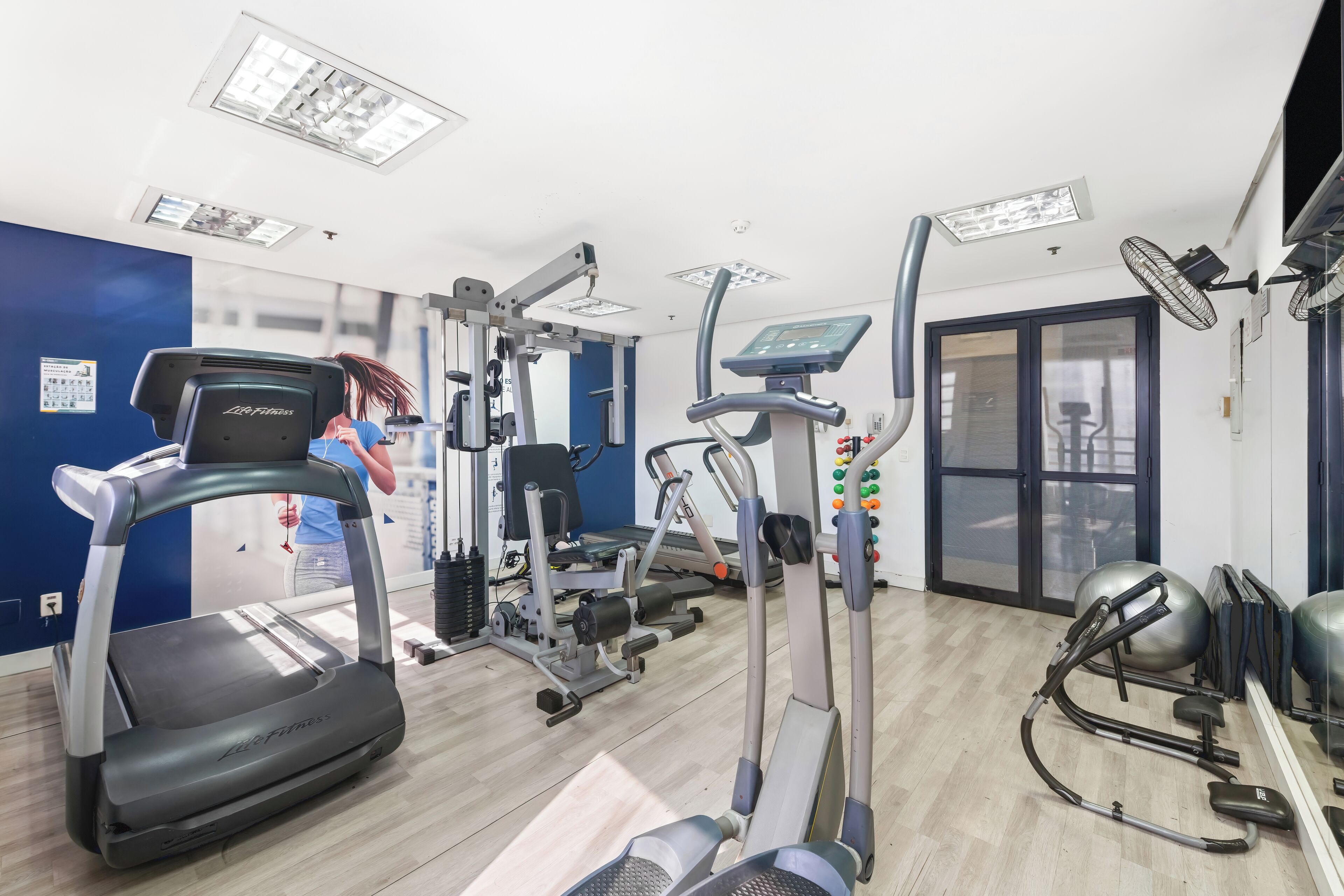 A gym with treadmills, elliptical machines, and weight equipment.