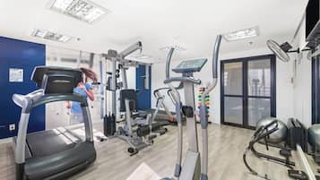 A gym with treadmills, elliptical machines, and weight equipment.