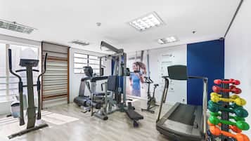 A gym with various exercise equipment, including treadmills, a stationary bike, and weight machines.