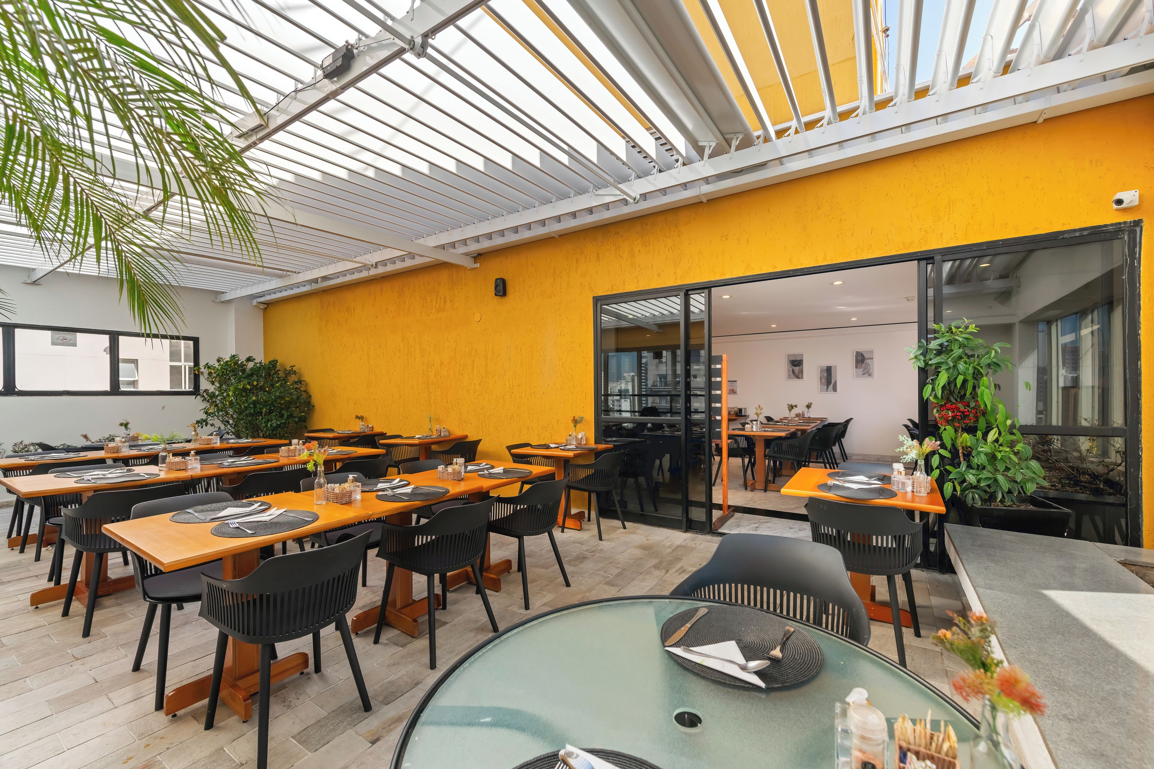Ein Restaurant mit Innenbereich, einer Glaskuppel und einer gelben Akzentwand.