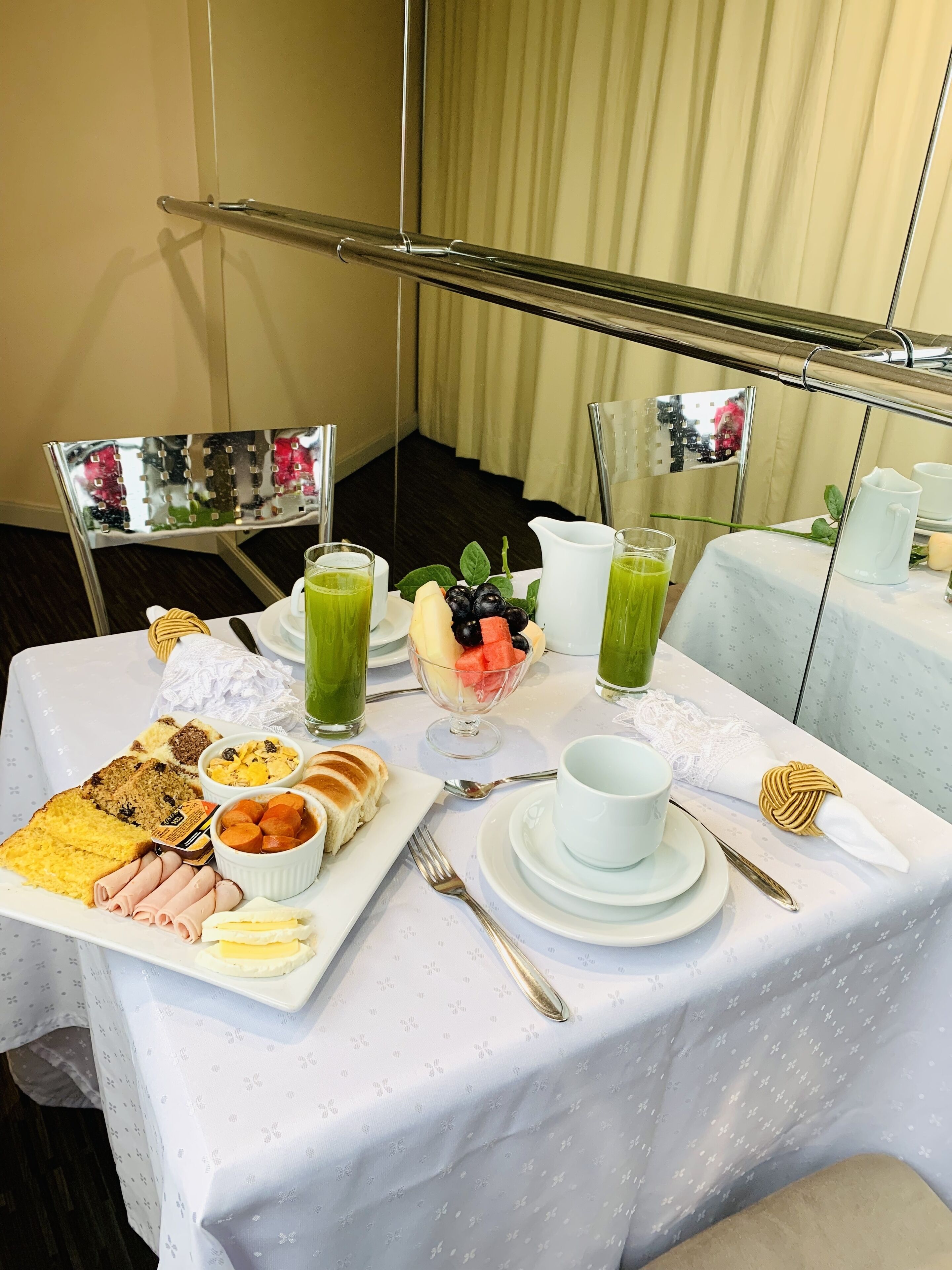 A breakfast table with various food items, including toast, fruit, and a bowl of cereal.