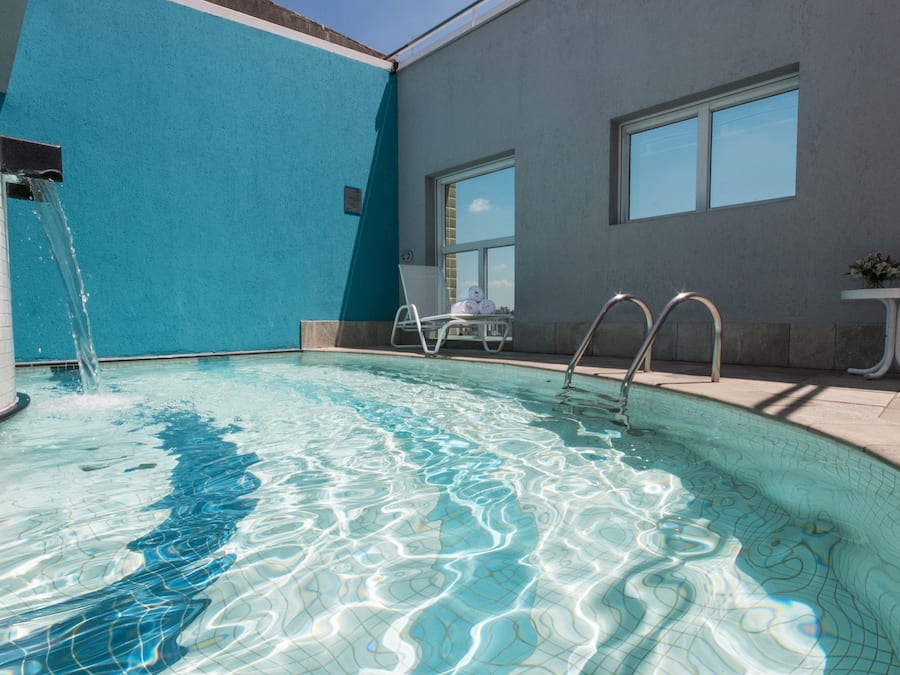 Een binnenzwembad, ligstoelen bij het zwembad
