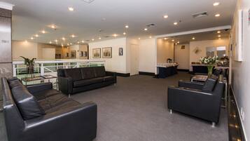 A lobby with a reception desk, a coffee station, and seating areas.