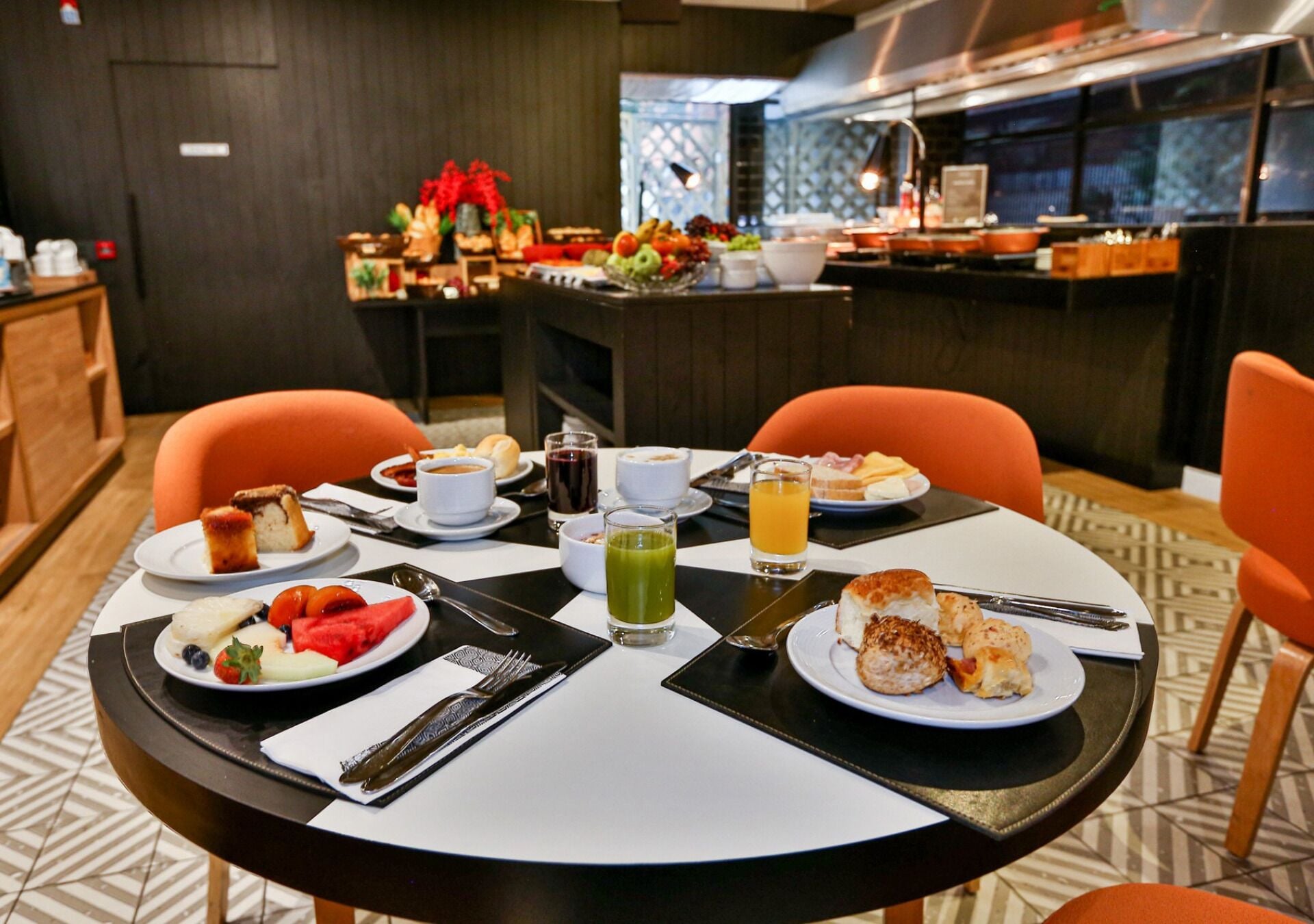A breakfast setting with a table set for two, including plates with food, drinks, and cutlery.