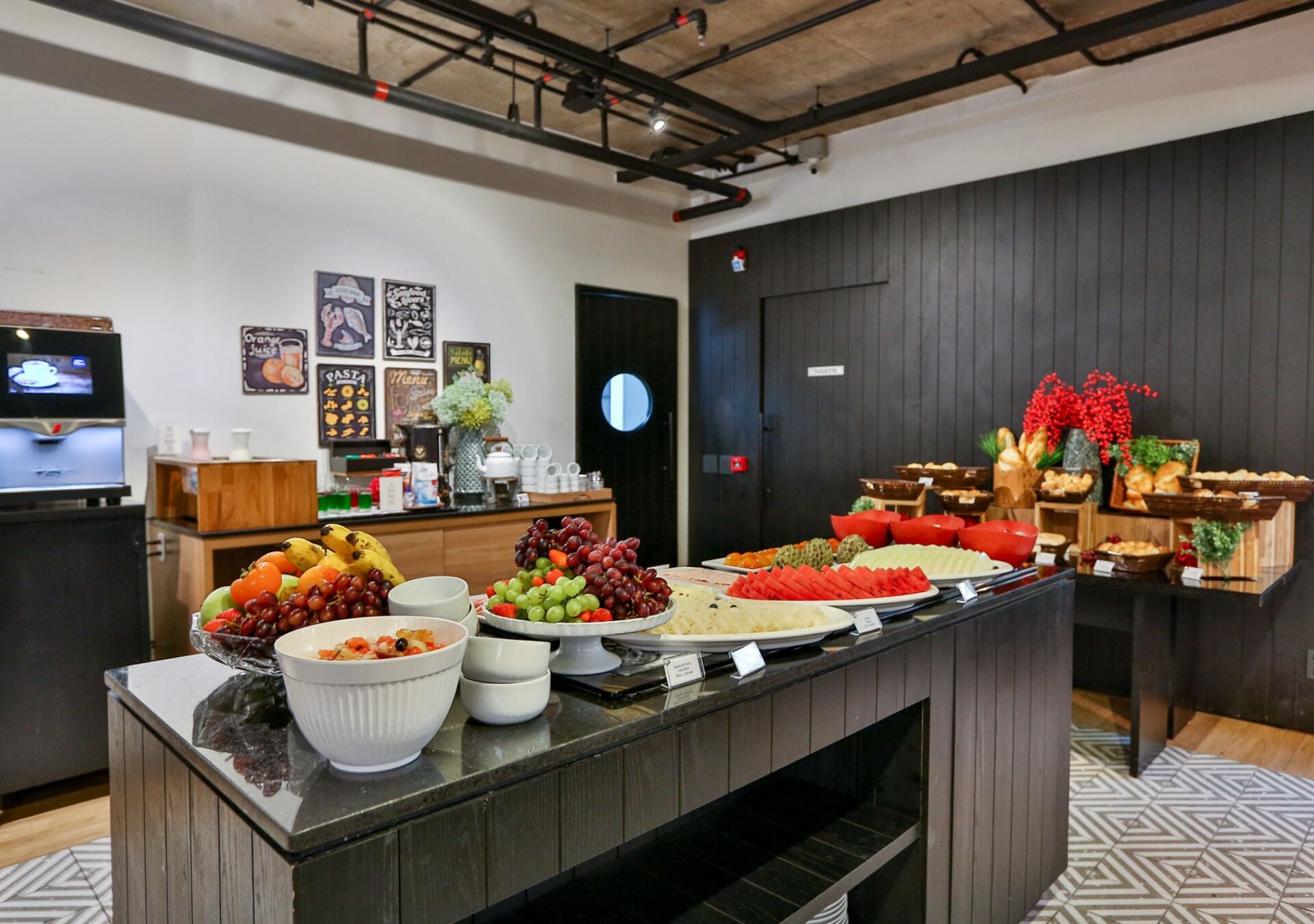 A buffet with various food items, a television, and a door with a circular mirror.
