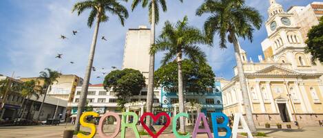 A plaza with a large sign spelling "SORCABA" and palm trees.