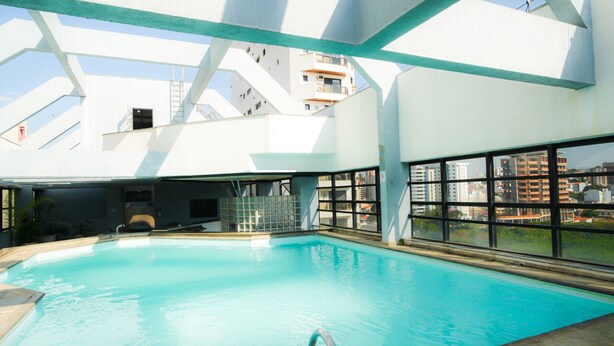 An indoor swimming pool with clear views of the cityscape through large windows. - Hotel Dan Inn Sorocaba by Nacional Inn (Sorocaba)