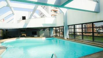 Una piscina al aire libre, tumbonas