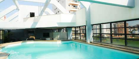 Una piscina al aire libre, tumbonas