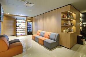 A modern hotel lobby with a seating area, a minibar, and a liquor display. - Transamerica Executive Chácara Santo Antônio (São Paulo)