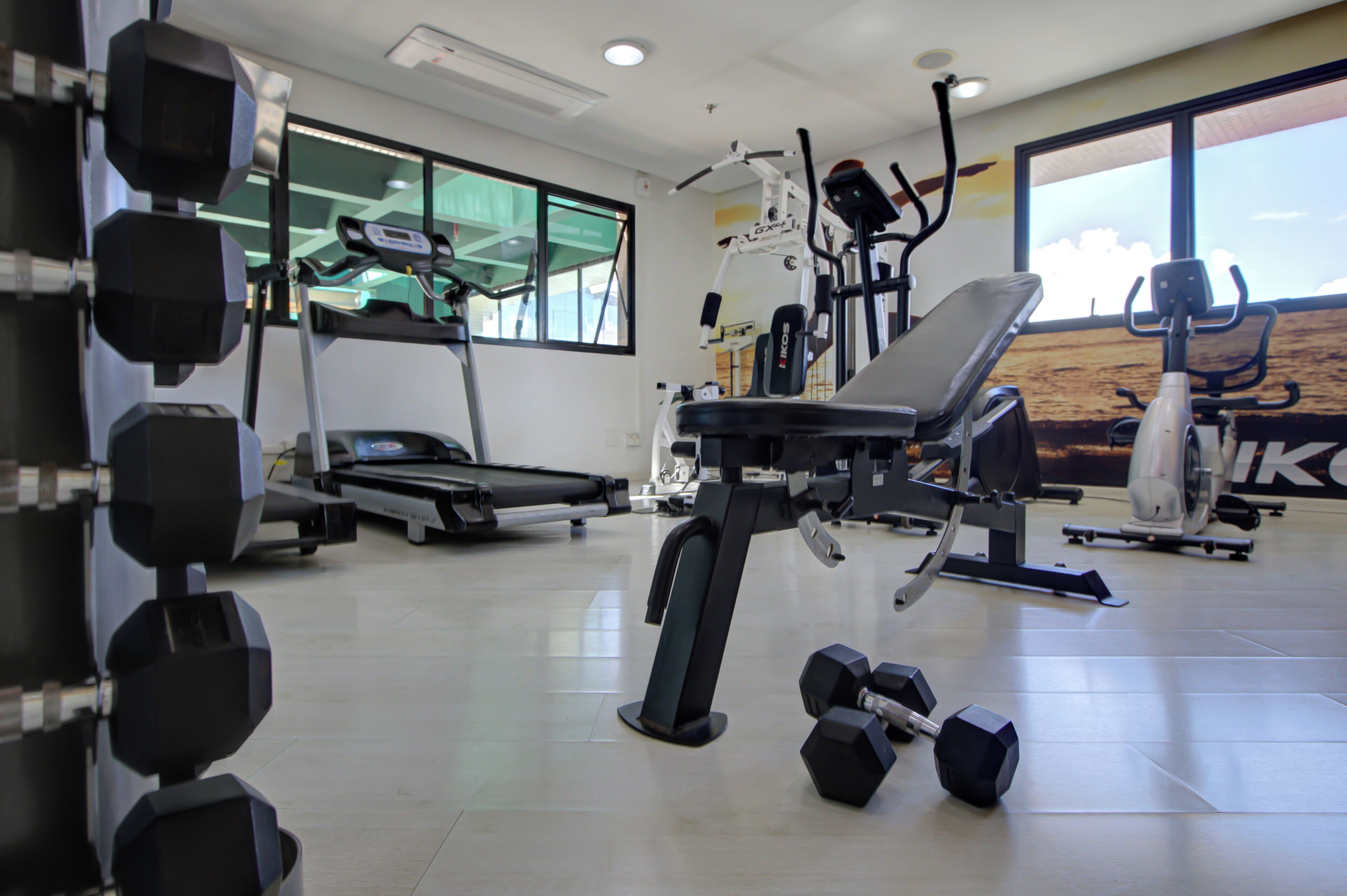 A gym with exercise equipment, a treadmill, and a large window.