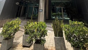The exterior of the San Diego Suites Loures hotel with a modern design, featuring a prominent entrance and a clear sky above. - San Diego Suites Lourdes (Belo Horizonte)