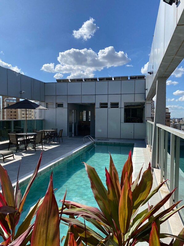 Una piscina al aire libre, sombrillas, tumbonas