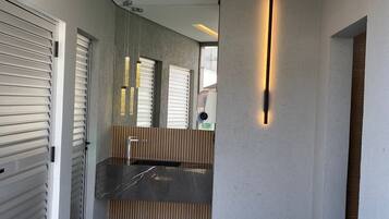 Una cocina moderna con una isla central, luces empotradas en el techo y vistas al exterior a través de un ventanal.