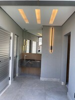 Una cocina moderna con una isla central, luces empotradas en el techo y vistas al exterior a través de un ventanal.