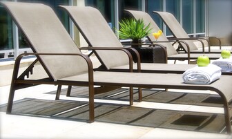 Una piscina al aire libre, sombrillas, sillones reclinables de piscina