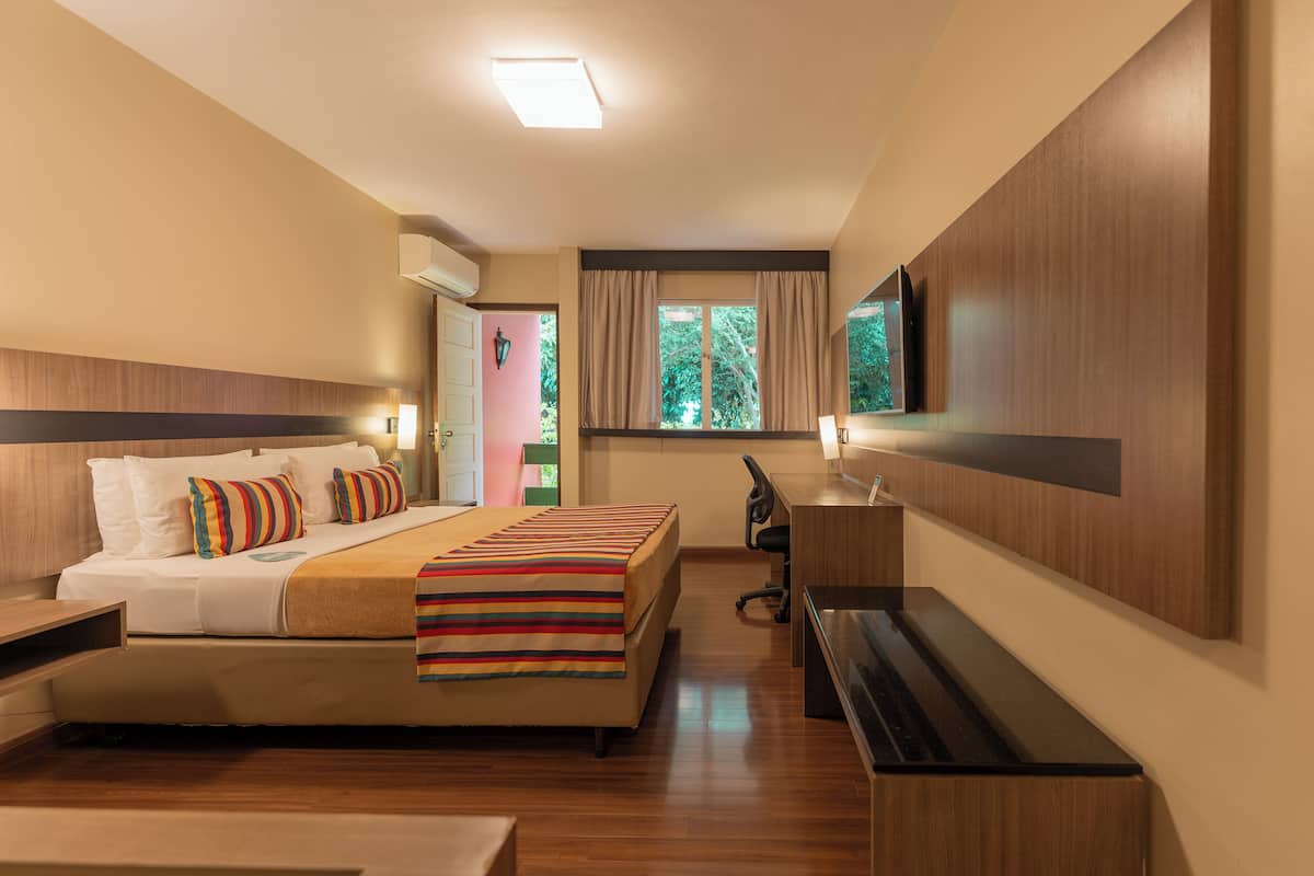 Una habitación de hotel con cama, escritorio y televisión.