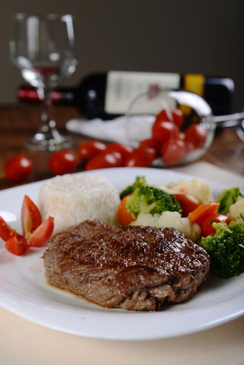 A plate with a steak, rice, and mixed vegetables.