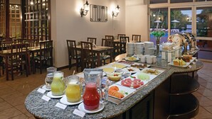 A buffet setup with various food items and drinks. - Hotel Deville Express Guaíra (Guaira)