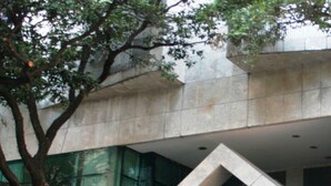 A modern building with a prominent entrance, a tree in front, and signs indicating a hotel and a business center. - Bristol Merit Hotel (Belo Horizonte)