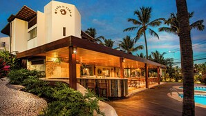 Un moderno resort con bar, piscina y jardines tropicales.