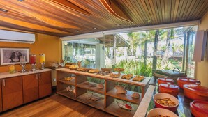 A breakfast buffet with various food items and a tropical view. - Casa Di Vina Boutique Hotel (Salvador)