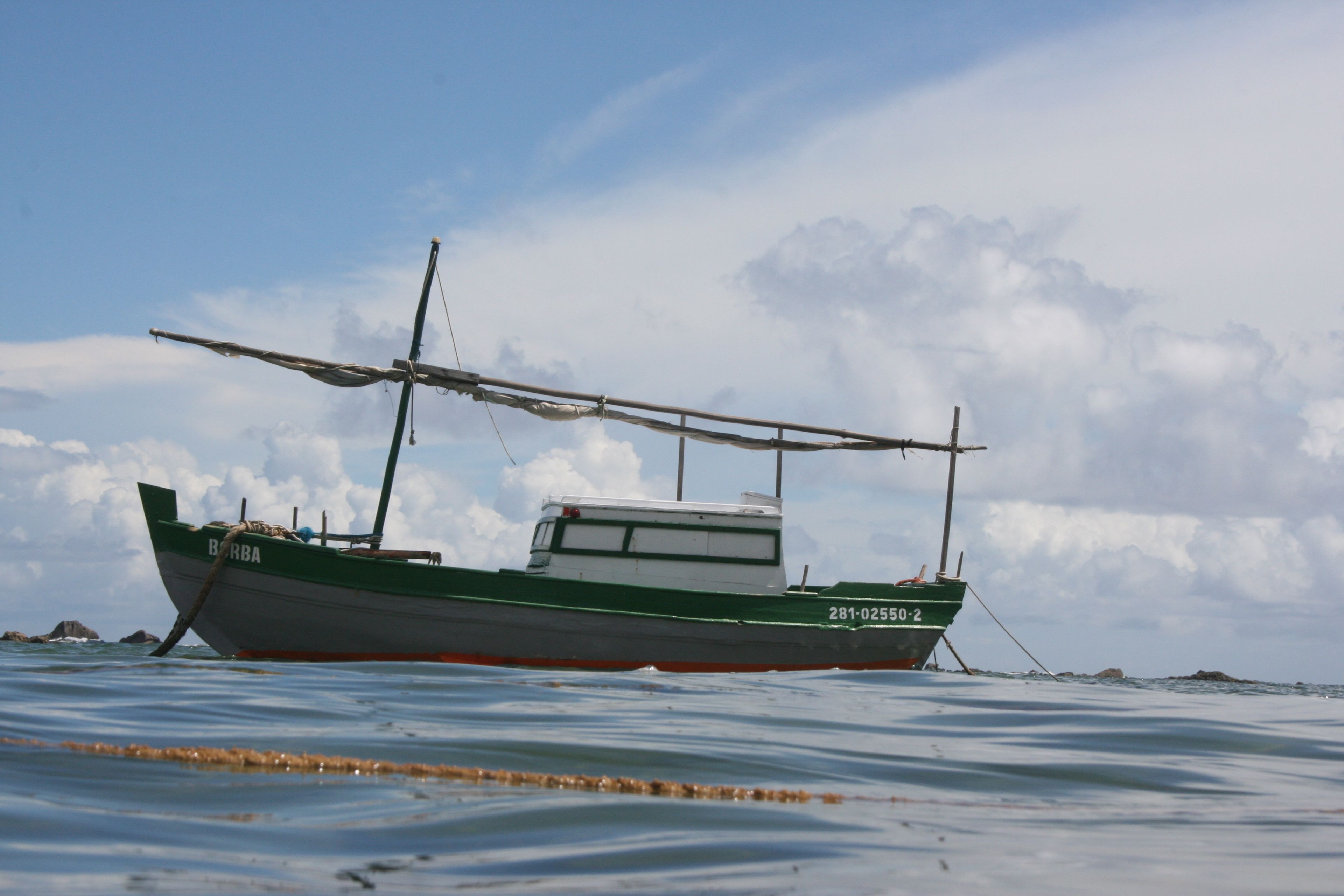 Un bateau portant le numéro 281-02550-2 sur sa coque, flottant sur une eau calme.