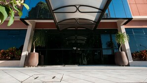 A modern building with a glass facade and a covered entrance. - Saint Peter Hotel (São José do Rio Preto)