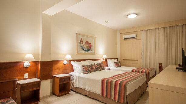 A hotel room with two beds, a desk, and a TV. - Saint Peter Hotel (São José do Rio Preto)