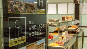 Un bufé de hotel con diversas opciones de comida y un cartel que indica que pertenece a Rede Andrade Hotels.