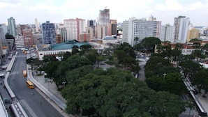 Un paisaje urbano con una zona verde prominente, una línea de tranvía y varios edificios.