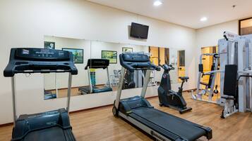 A gym with treadmills, stationary bikes, and weight machines.